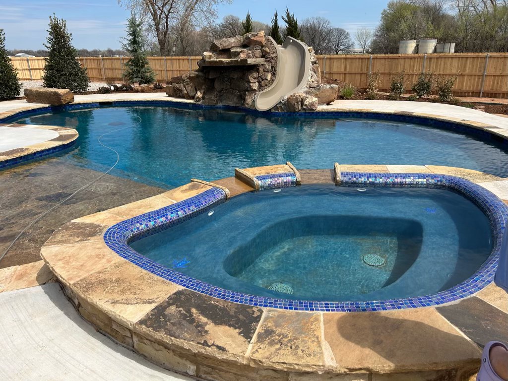 Freeform pool with slide, rock feature and glass-tile spa, Oklahoma